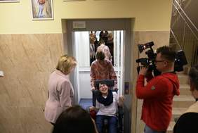 Pokaż zdjęcie: Uczeń niepełnosprawny poruszający się na wózku inwalidzkim testuje nową windę.