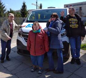 Pokaż zdjęcie: Czworo uśmiechniętych Uczestników WTZ os. Dywizjonu 303 pozuje na tle nowego samochodu