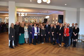 Zdjęcie grupowe uczestników uroczystości w dużej przestronnej sali