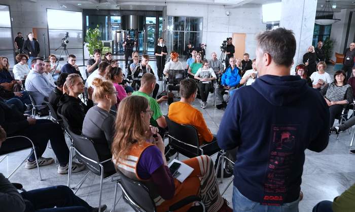 Pokaż zdjęcie: Zdjęcie z nagrań do programu autentyczni, osoby siedzą na krzesłach i rozmawiają ze sobą, w tle widać kamerzystów