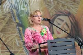 Pokaż zdjęcie: Kobieta blondynka stoi przy mównicy