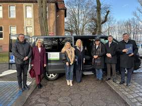 Pokaż zdjęcie: Uczestnicy uroczystości stoją do zdjęcia na tle nowego busa