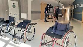 Pokaż zdjęcie: Na pierwszym planie wózki inwalidzkie, a w tle wywiadu dla TVP3 Bydgoszcz udziela Dyrektor Oddziału Kujawsko-Pomorskiego PFRON - Aleksandra Gierej