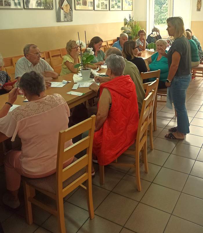 Pokaż zdjęcie: Uczestnicy spotkania przy stole dyskutują z rehamanagerem