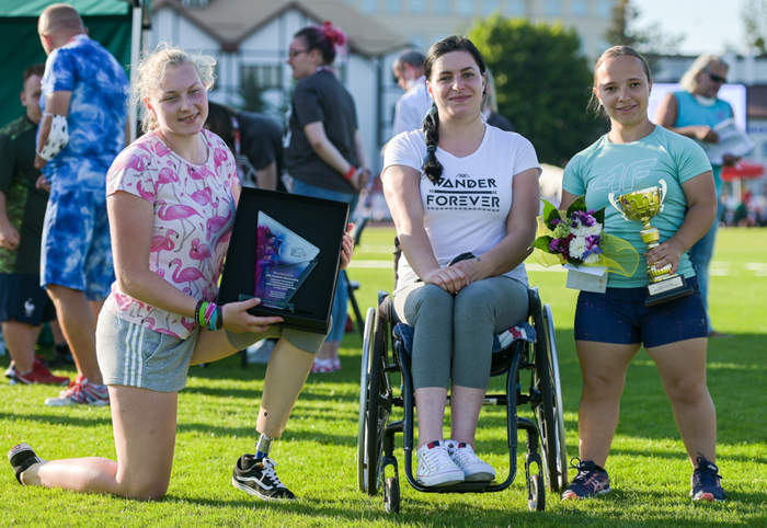 Pokaż zdjęcie: Najlepsze kulomiotki w konkursie o Puchar PFRON (trzy kobiety trzymają nagrody, kobieta w środku porusza się na wózku inwalidzkim) fot. Mateusz Słodkowski/Trojmiasto.pl