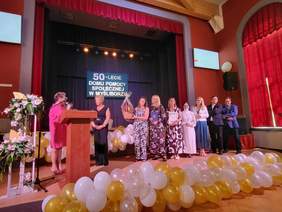 Pokaż zdjęcie: Wręczanie przez zaproszonych gości upominków, kwiatów i życzeń