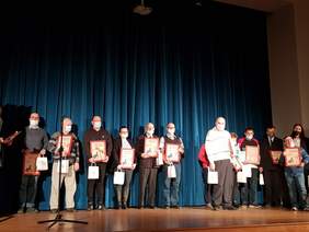 na scenie, na tle ciemno niebieskiej kotary grupa kilkunastu osób pozuje do zdjęcia