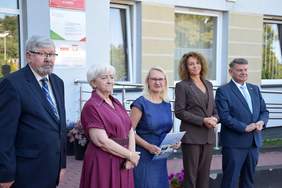 Pokaż zdjęcie: Przed budynkiem ŚDS w Łasku stoi pięć osób: trzy kobiety i dwóch mężczyzn. Trwa oficjalne przekazanie samochodu dla uczestników placówki. 