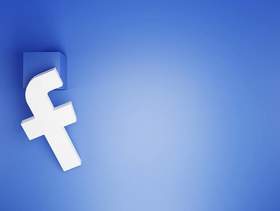 Białe logo Facebooka na niebieskim tle.