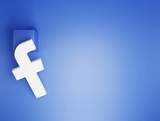 Białe logo Facebooka na niebieskim tle.