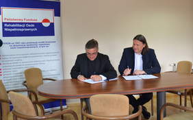 Pokaż zdjęcie: Podpisanie porozumienie z UKSW na rzecz osób niepełnosprawnych, od lewej ks. prof. dr hab. Stanisław Dziekoński - Rektor UKSW, Robert Kwiatkowski - Prezes PFRON 