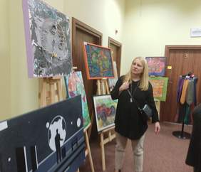 Pokaż zdjęcie: pomieszczenie Oddziału Łódzkiego po jednej i drugiej stronie rozmieszczono sztalugi z obrazami i pracami uczestników po środku stoją członkowie komisji i  oceniają prace konkursowe