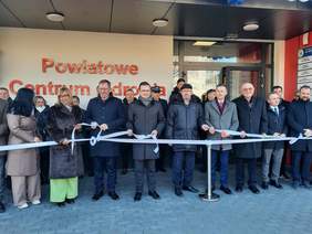 Pokaż zdjęcie: Przed Powiatowym Centrum Zdrowia w Opocznie stoją ludzie. Za chwilę odbędzie się symboliczne rozwiązanie wstęgi oznaczające otwarcie placówki. Wszyscy są w dobrych nastrojach.   