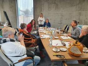 Pokaż zdjęcie: Osoby siedzące przy stole podczas narady