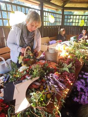 Pokaż zdjęcie: Kobieta układająca bukiety z roślin  