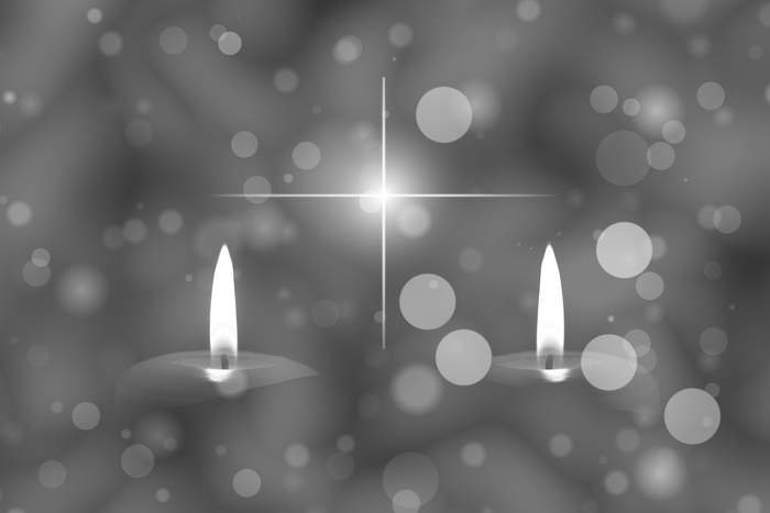 palące się dwa znicze, nad nimi blask gwiazdy na niebie