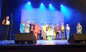 Na scenie stoją alaureaci i zaproszeni goście