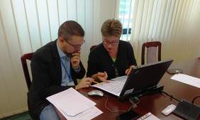 Pokaż zdjęcie: Pracodawca i jeden pracownik Oddziału.  Siedzą przy stoliku, na którym stoi laptop i leżą dokumenty 