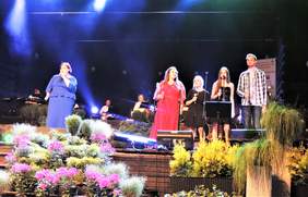 Pokaż zdjęcie: Uczestniczka konkursu i chórek występują na scenie podczas Festiwalu