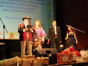 Pokaż zdjęcie: Uczestnicy IV Przeglądu Twórczości Artystycznej Środowiskowych Domów Samopomocy Województwa Małopolskiego im. Haliny Wędrychowicz. Uczestnicy w trakcie występu na scenie.