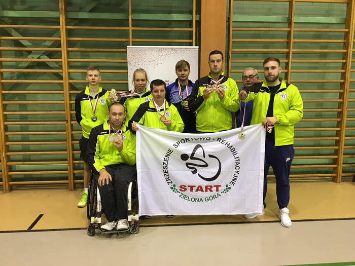 Pokaż zdjęcie: Sportowcy "Startu" Zielona Góra z flagą zespołu ze zdobytmi medalami na tle hali