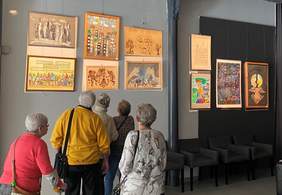 Pokaż zdjęcie: Pięcioosobowa grupa oglądająca prace podczas wernisażu