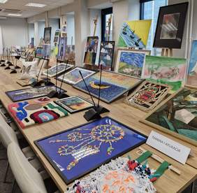 Pokaż zdjęcie: Rozłożone na dużym stole prace plastyczne