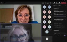 Pokaż zdjęcie: Zrzut ekranu z platformy Microsoft Teams przedstawia twarz uśmiechniętej kobiety w okularach, która prowadzi spotkanie w formule online. Poza tym widoczna jest również twarz kobiety w okularach, która uczestniczy w spotkaniu oraz inicjały pozostałych uczestników. Ponadto można dostrzec również wiele standardowych ikonek, które umożliwiają prowadzenie webinarium za pośrednictwem platformy Microsoft Teams.  
