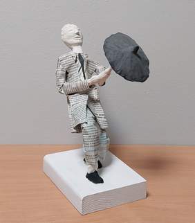 Pokaż zdjęcie: rzeźba przedstawia mężczyznę w garniturze trzymający otwartą parasolką przed sobą